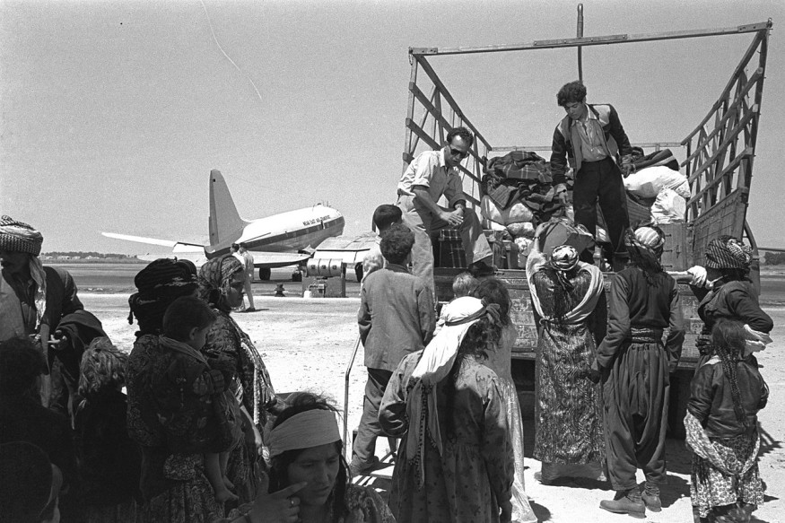 “Esdras y Nehemías”. Inmigrantes iraquíes saliendo del aeropuerto de Lod camino a una ma'abara (campo de tránsito), 1951. Wikimedia commons.