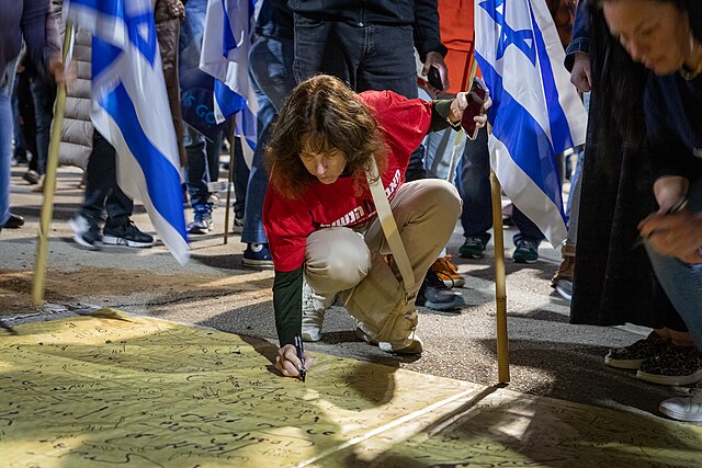 Manifestantes firman simbólicamente un pliego de la Declaración de Independencia. Raanana, Abril de 2023