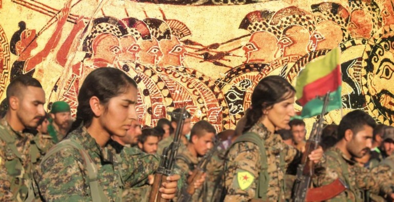Los combatientes de YPG e YPJ están firmes (primer plano), el jarrón Chigi representa falanges de hoplitas (fondo).
